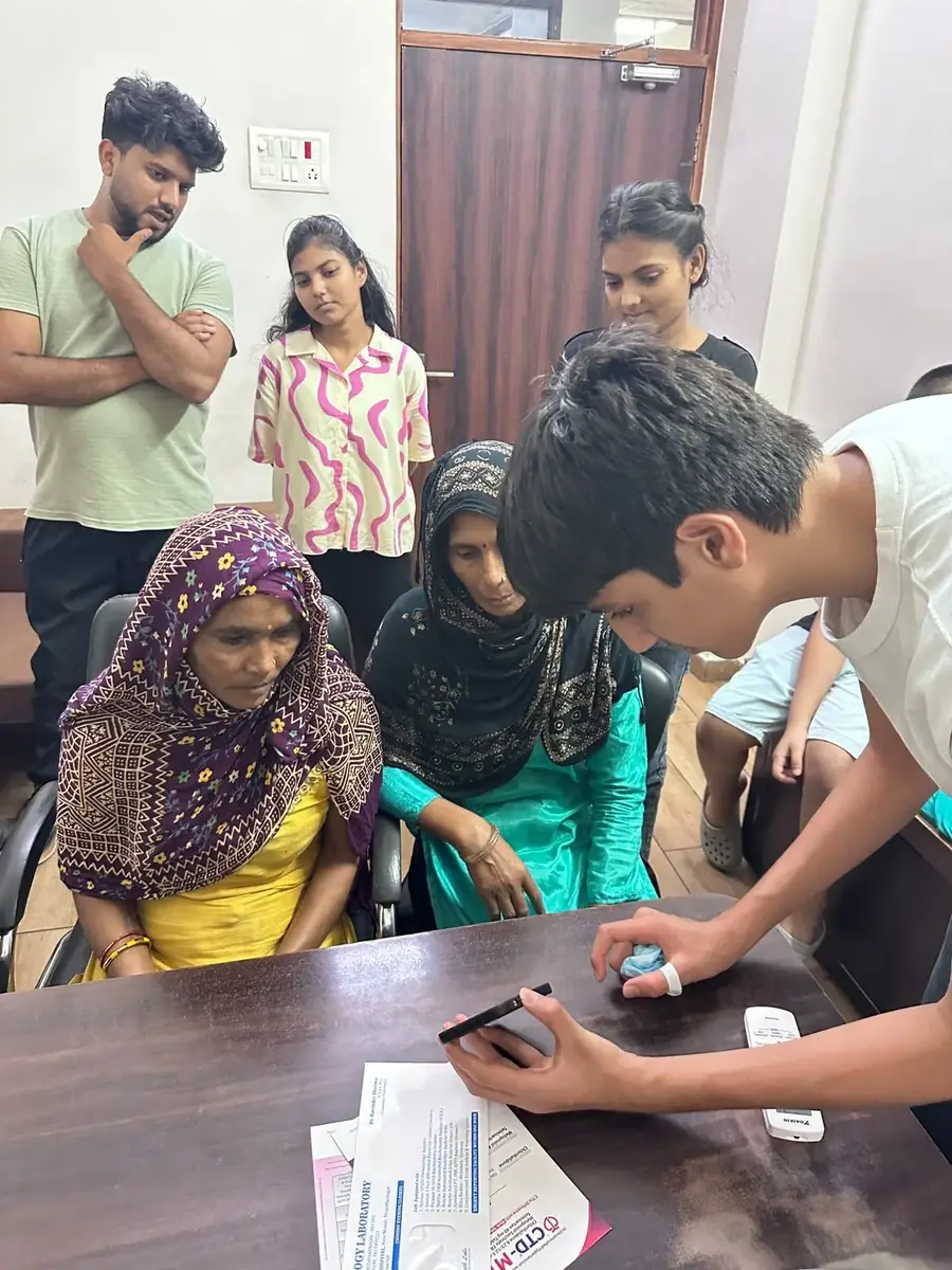 Kabir walking two patients through their reports on his phone
